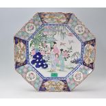 A good 18th century Chinese octagonal wall charger plate with central scenes of Geisha and houses