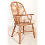 An early 20th Century light oak Windsor armchair / chair being raised on turned splayed legs
