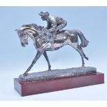 Horse Racing - A silver hallmarked over resin figure depicting a race horse and jockey in mid race