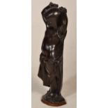 A late 19th Century cast bronze figure of slave girl having raised manacled arms set to a wooden