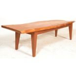 A mid century rustic long john coffee table being raised on square tapering legs with rustic live