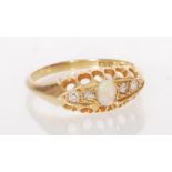 A stamped 18ct gold ladies ring set with an oval cut opal flanked by four white stones in a