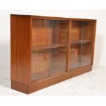 A mid century teak wood / 1970's library bookcase cabinet being raised on a plinth base with sliding