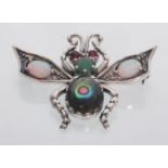 A sterling silver art nouveau style bug brooch set with opal panels and ruby eyes. Gross weight 7.