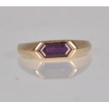 A stamped 375 9ct gold ladies ring set with a faceted purple stone panel to the head with faceted