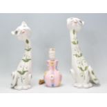 A pair of vintage retro Italian cat figurines of elongated stylised form being hand painted with