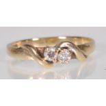 A hallmarked 9ct yellow gold ladies ring set with two central faceted round cut white stones on a