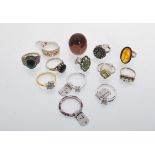 A selection of thirteen silver rings to include an amber cabochon ring within a rope twist