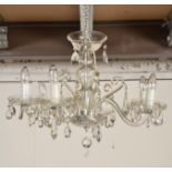 An early 20th century 8 branch glass chandelier. Each glass arm with glass well beneath single