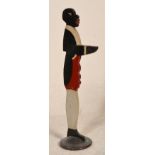 An early 20th century painted metal negro dumb waiter being of wooden construction and hand painted