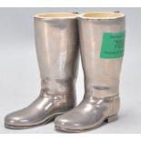 A pair of vintage silver plated drinks measures in the form of riding boots having white measure
