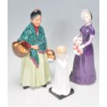 A group of three Royal Doulton ceramic figurines to include The Orange Lady, Good Day Sir H.N.