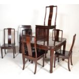 A large 20th century Chinese mahogany dining table and chairs suite. The large table with carved and