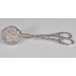 A pair of silver tongs having moulded and engraved flower heads decoration with rose and scroll