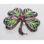 A  sterling silver plique a jour four leaf clover brooch set with a central ruby cabochon. Gross