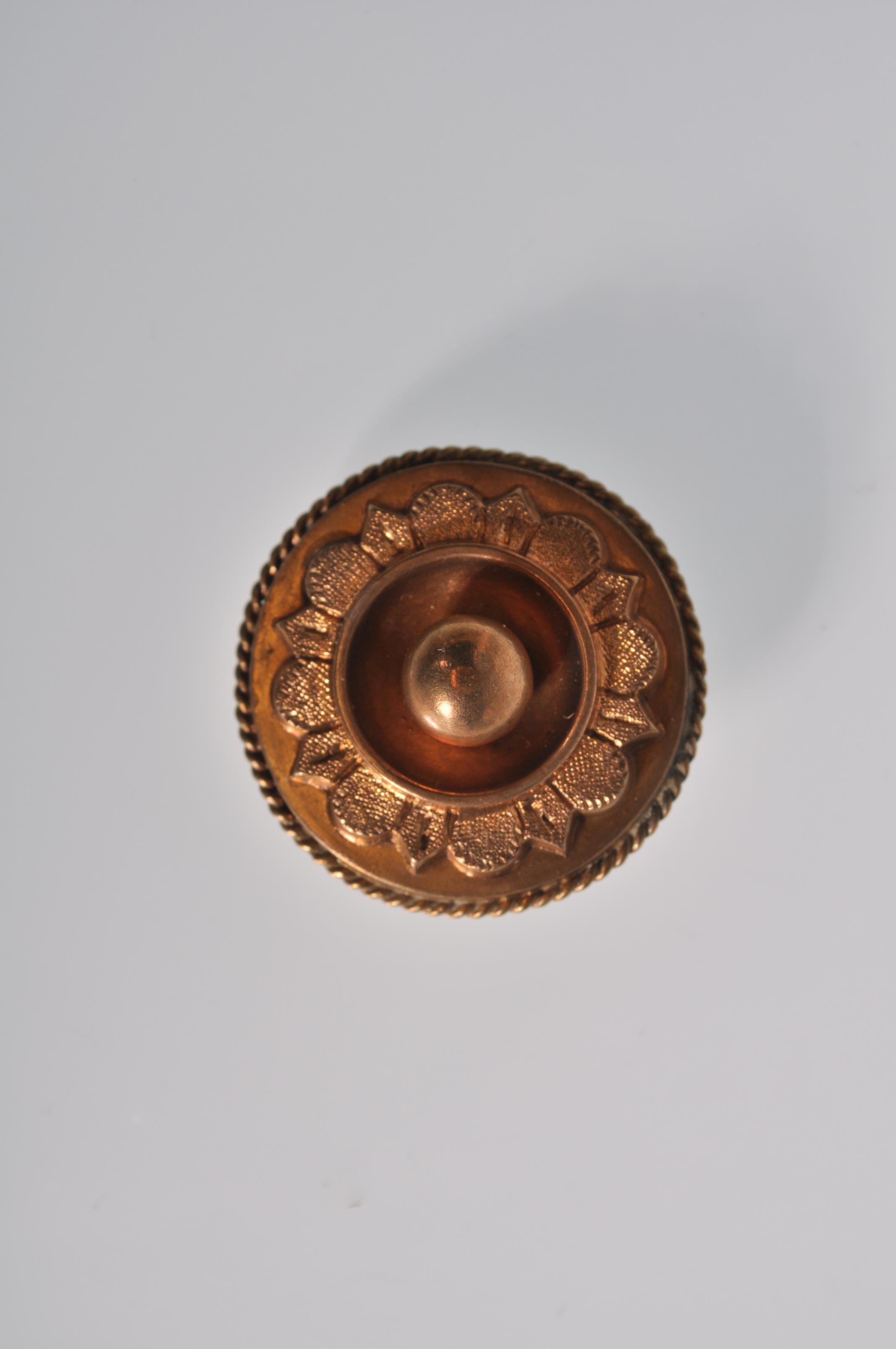 A 19th Century Victorian gold tone brooch of circular form with raised and engraved decoration