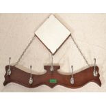 A 1930's Art Deco diamond shaped mirror having unusual hanging yoke shaped coat rack on chain. The