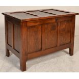 A 20th century antique style oak coffer raised on squared legs with fielded panel body and sides