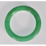 A Chinese green jade bangle of typical round form. Interior diameter 5.4cm. Weighs 73g.