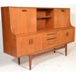 A retro 20th Century teak wood G-Plan highboard sideboard credenza being raised on tapering