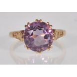 An English hallmarked 9ct yellow gold ladies ring prong set with a large purple faceted cut round