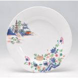 A 19th Century Chinese polychrome wall charger plate of round form being hand painted with pagoda's,