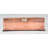 A good 20th Century Arts and Crafts style copper cigarette box raised on wooden feet with the hinged