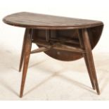 A retro 20th Century 1970's Ercol dark beech and elm circular circular coffee table raised on