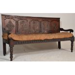 An 18th century large carved West country oak hall settle bench. Raised on turned legs with