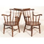 A pair of Victorian 19th century beech and elm wood Windsor armchairs being raised on turned legs