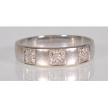 An 18ct white gold band ring having three illusion panels set with white stones. Stamped 750. Weighs