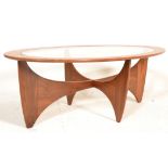 A mid century G-Plan ‘ Astro ‘ pattern teak wood and glass coffee table of oval form raised on