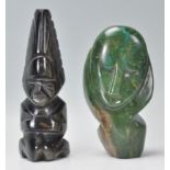A carved tribal tiger stone figure together with a carved green soapstone figure of a face.