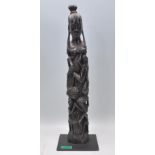 A carved ebonised wooden African tree of life tribal figurine depicting entwined figures culminating
