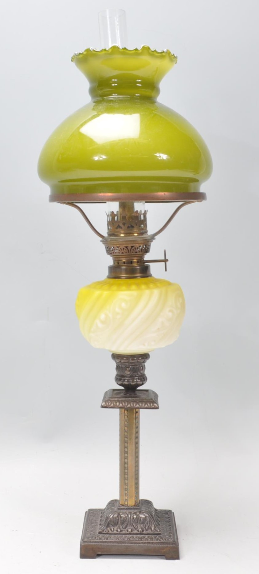 A 19th Century Victorian oil lamp of small proportions being raised on a square stepped base