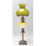 A 19th Century Victorian oil lamp of small proportions being raised on a square stepped base