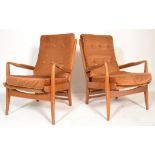 A pair of mid century teak wood Cintique armchairs. Each raised on show wood a-frames with