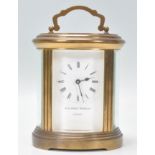 A 20th Century Matthew Norman of London oval brass carriage clock, with Roman numerals and key wind