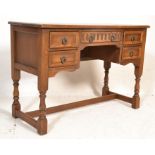 A 20th century Old Charm oak writing table desk being raised on turned legs with stretchers having