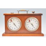 A vintage teak cased chess clock / timer of rectangular form having two white enamelled dials with