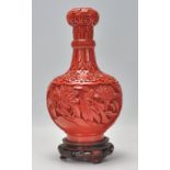 A Chinese red cinnabar carved lacquer garlic head shape bottle vase being decorated with intricate