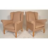 A pair of mid century retro wingback armchairs in the manner of Howard Keith. The chairs being