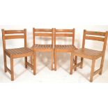 A set of 4 mid century beech wood slatted dining chairs being raised on squared legs with slatted