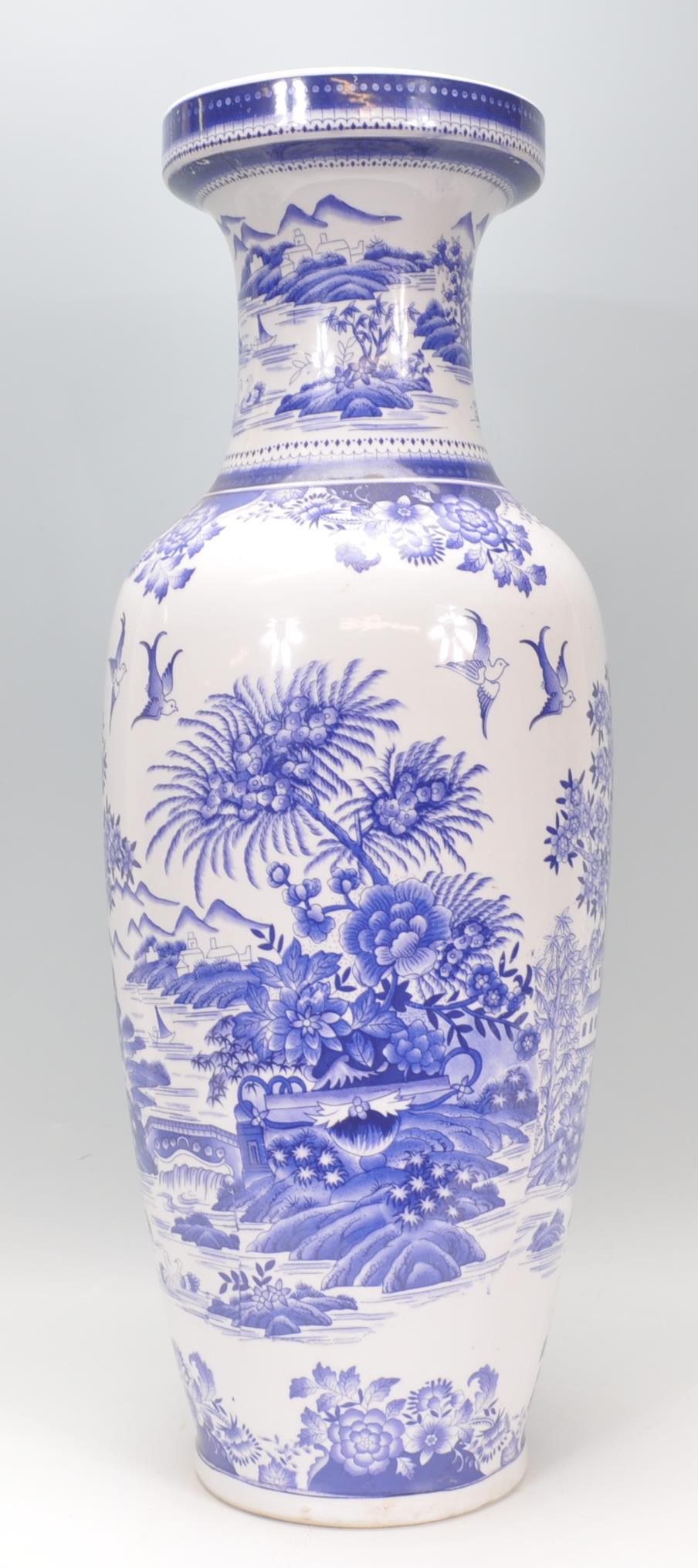 A large 20th century Chinese floor standing blue and white vase depicting fauna and birds with a