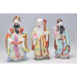 A group of three Chinese polychrome ceramic figures of the Sanxing deities each being hand painted