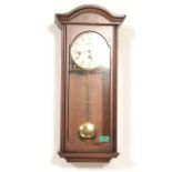 A 20th century mahogany cased Woodford wall clock having inset 8 day movement with circular white