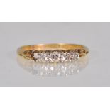 A stamped 18ct gold and diamond ring set with four round cut diamonds within a scrolled setting.