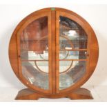 A 1930's Art Deco walnut roundel china display cabinet vitrine. Raised on a scroll plinth with