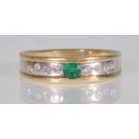 A 14ct yellow gold ladies ring having a two tone coloured mount channel set with a central round cut