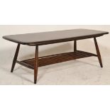 A retro 20th Century Ercol dark beech and elm coffee table raised on tapering supports united with